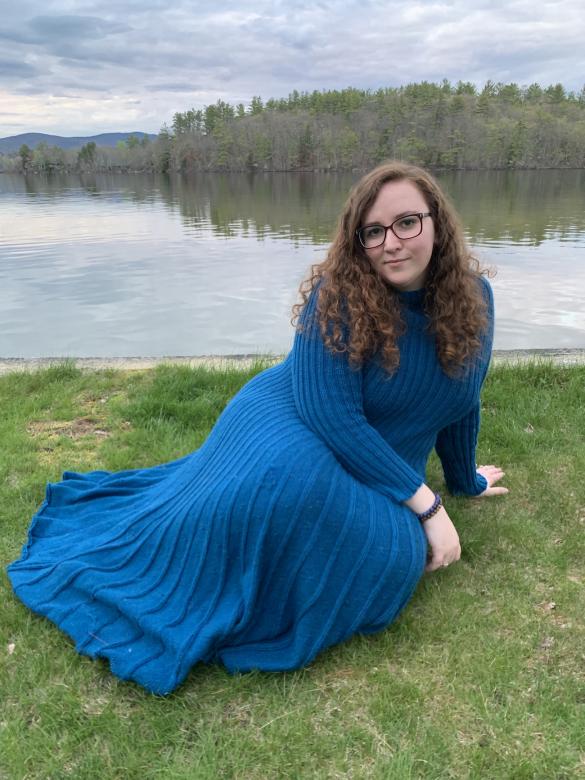 kiera rowe sitting in front of lake in blue dress