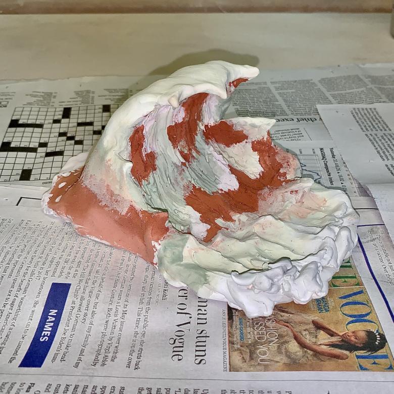 sculpture of ocean wave painted with glaze before going into the kiln