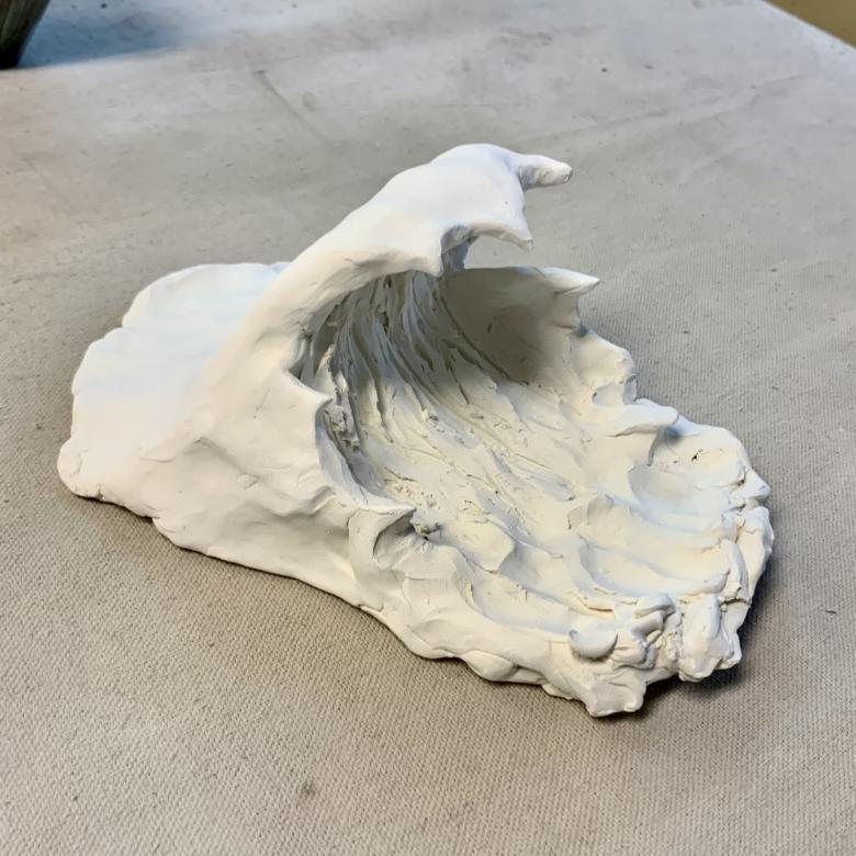 dried clay sculpture of ocean wave before the glaze 