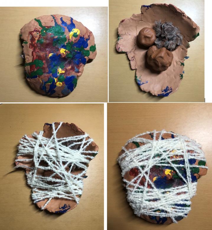 Four distinct views of a mixed media terracotta colored clay sculpture. The top left image shows the terracotta form painted with blue, red, yellow, and green prints. The top right shows the form turned upside down cradling two clay balls and a furry piece of wool. The bottom left shows the form still turned over but wrapped in white fuzzy yarn all around. The bottom right image shows the sculpture turned rightside up still wrapped in white fuzzy yarn.