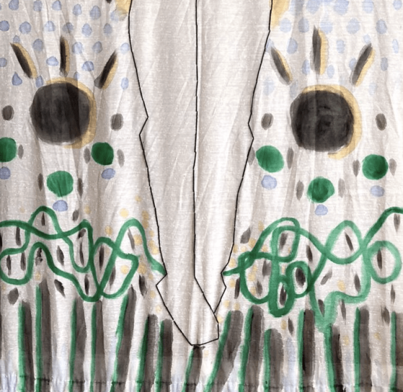 Close up of bottom half of large stitched black outline of a figure with no features other than black stringy short hair. Around the figure are orange, blue, green, and black symbols and shapes creating a landscape. 
