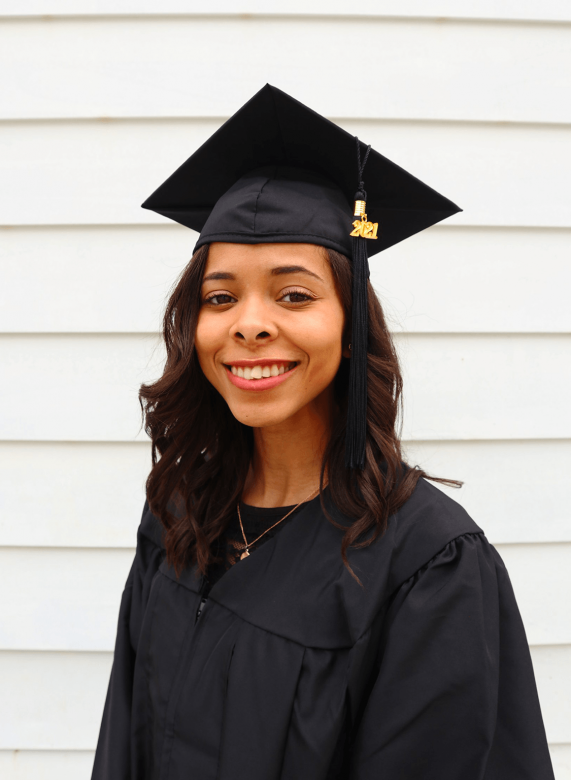 Madalena smiles while wearing her cap and gown. 