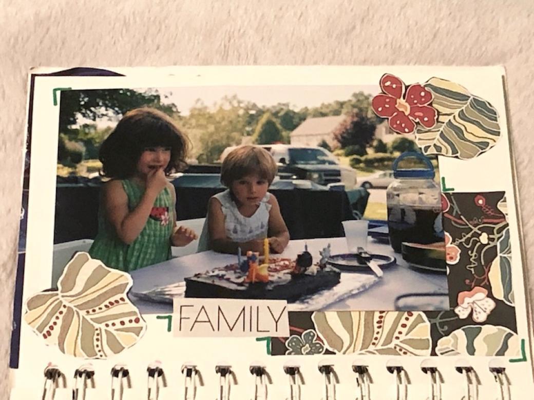 Page five shows a picture of me on my third birthday with short brown hair and a bright green dress. Sitting next to me in the photo is my younger brother with short blonde hair looking at my chocolate cake on the table in front of us. The word “FAMILY” is shown at the bottom of the page with tropical leaves around the border.
