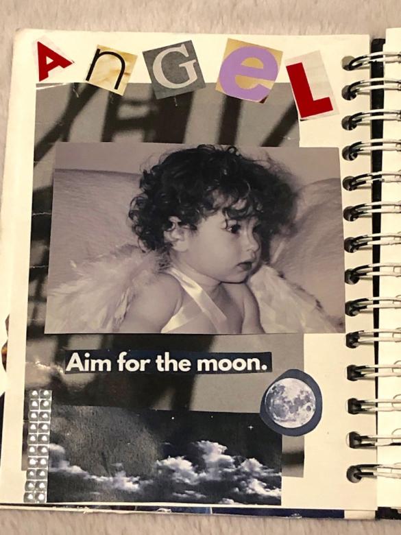 Page three has a dark grey and black background with a picture of myself (age two) wearing angel wings. Cut outs from magazines at the top of the page feature the word “angel” and at the bottom of the page a starry night and moon cut outs read “Aim for the moon”. 