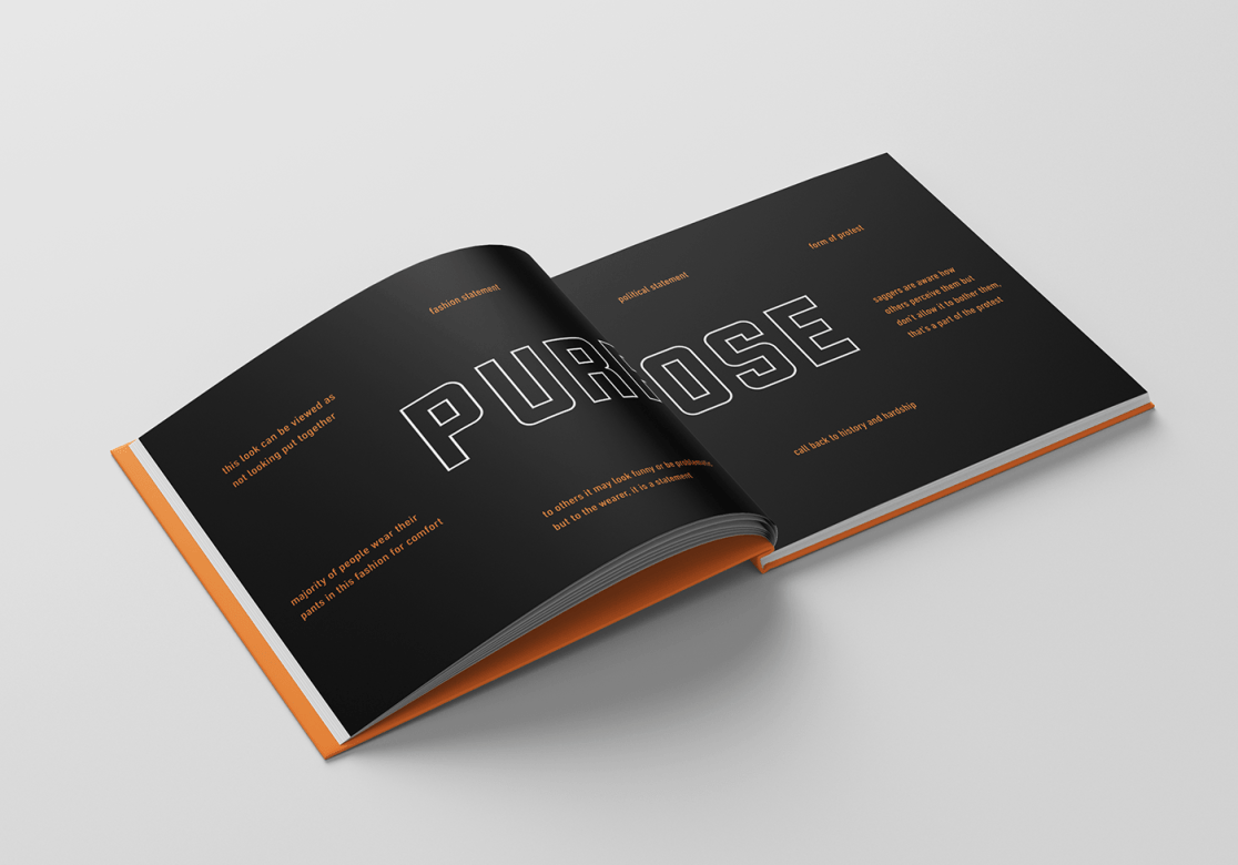 "Saggin" book open. Both pages are black with the word "PURPOSE" printed in the middle crossing over both pages. Surrounding "PURPOSE" are bits of text. Some of the text reads, "fashion statement, political statement, form of protest, call back to history and hardship."
