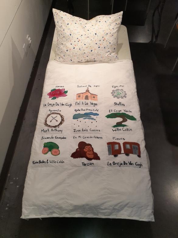 bed with drawings and writing painted onto the comforter