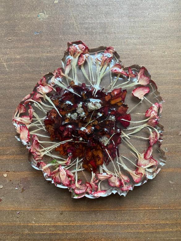 flower petals inside hardened resin, shaped like a coaster