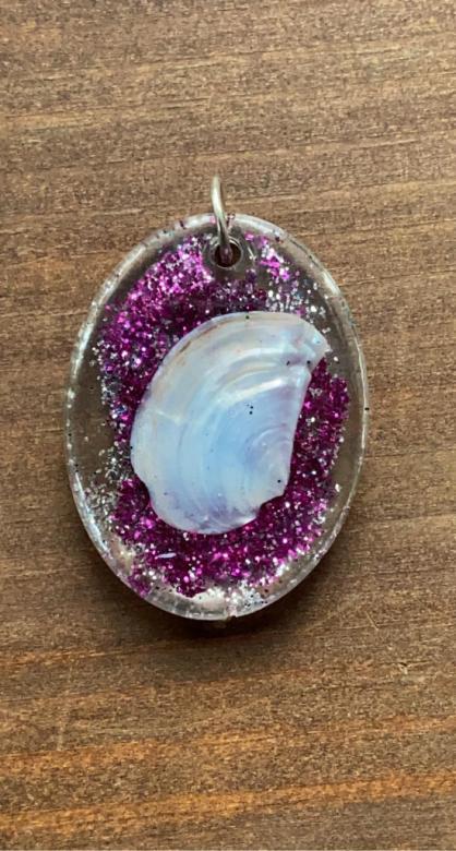 sparkly pink charm with a shell inside