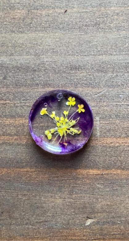 circular purple charm with yellow flowers