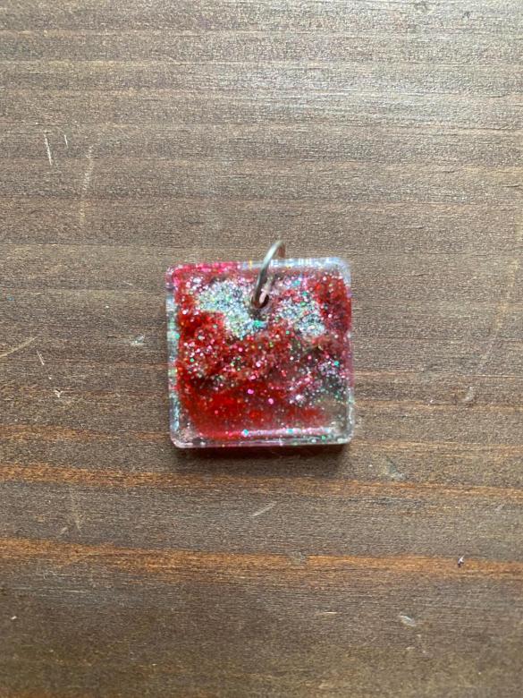 red and silver sparkly square-shaped charm