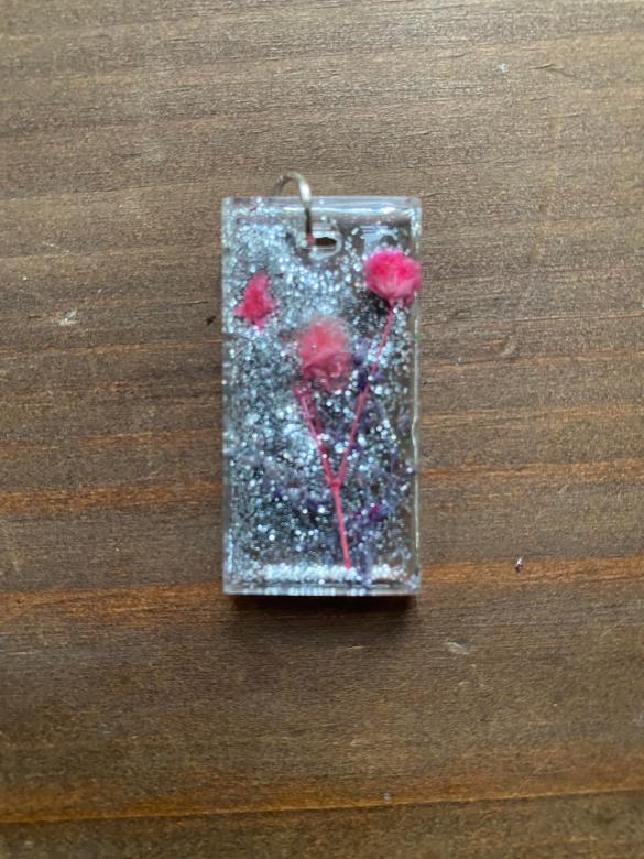 rectangular charm with silver sparkles and pink flowers