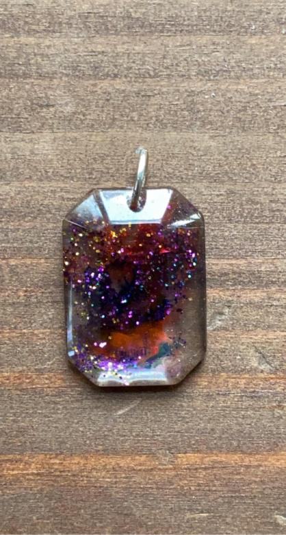 dark red and purple sparkles in a square-shaped charm