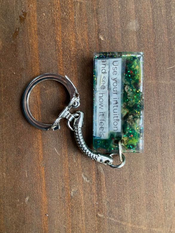 green keychain that reads, "Use your intuition and see how it feels."
