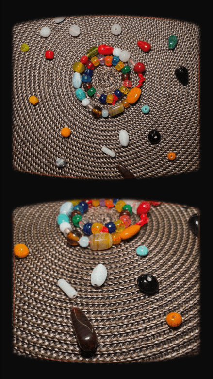 Mixed Media Photograph. There are two circles of colorful beads on string in the center, one bigger one surrounding a smaller one. Several differently shaped and colored beads surround the outside. The beads are placed on a woven mat with a circular pattern. There are two photographs of it, one shows the top view and the other a side view.