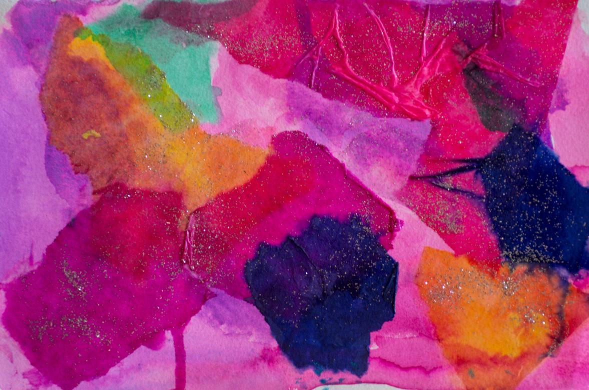 Areas of colored tissue paper pink, both light and dark, turquoise, navy blue, orange, and purple are arranged overlapping across the piece with the tissues appearing textured in some areas. There is silver glitter scattered across the piece.