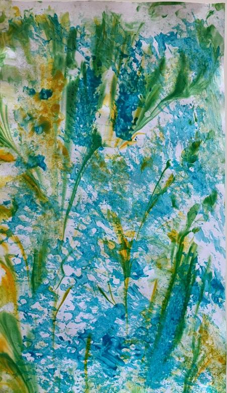 This piece has a blue background. The blue is marbled lightly on the paper with many gaps and holes that show the white background through it. Marbled over this are thin streaks of green and yellow paint.