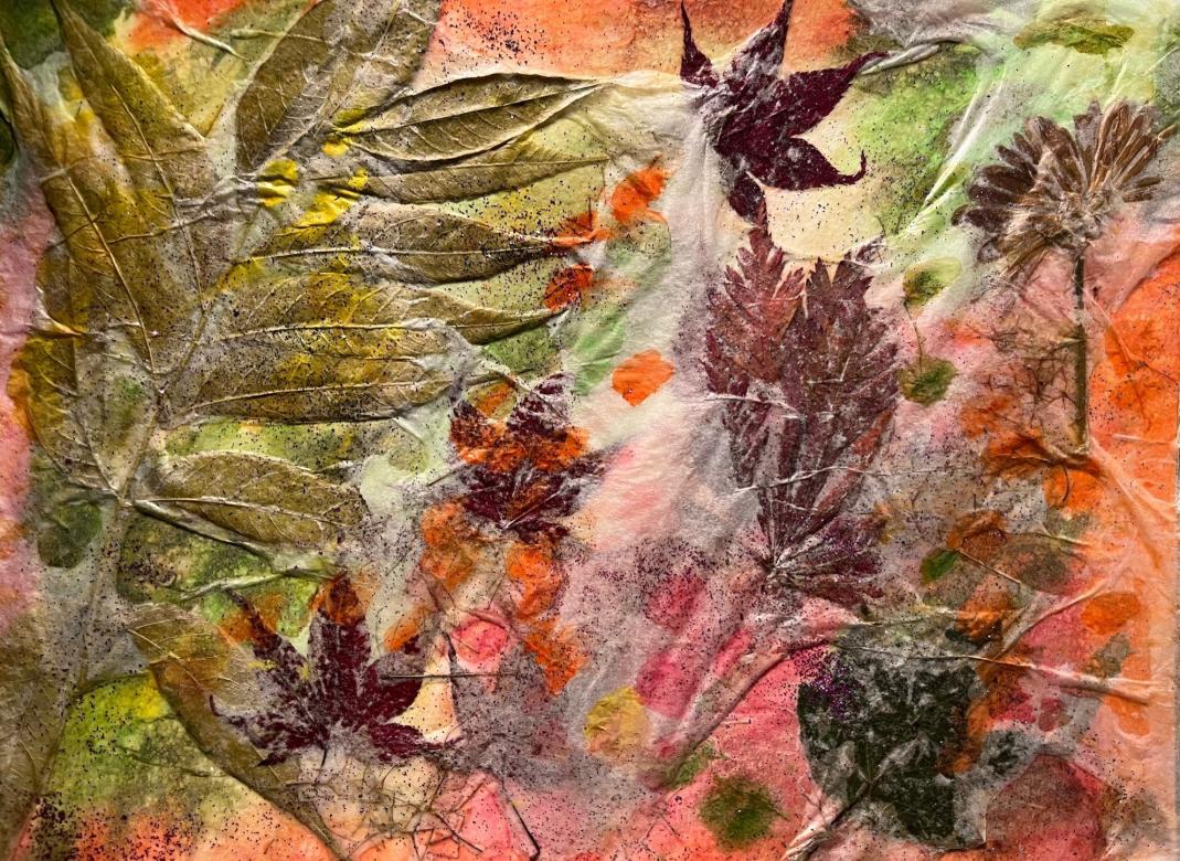 A background of several colors including orange, red, green, and yellow. Overlayed on this background are several different shapes and sizes of leaves and flowers. Overtop of them is a thin transparent silver tinted layer. Additionally, there is purple glittered scattered across the whole piece.