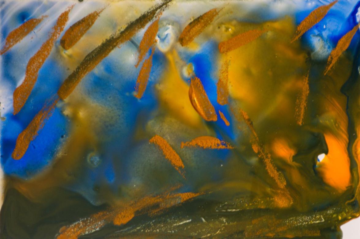 The background is made up of the colors green, orange, and blue. The bottom of the piece is mainly green and orange, but as it moves up the blue is mixed in as well. Over top of this is painted small streaks of shimmery orange paint.