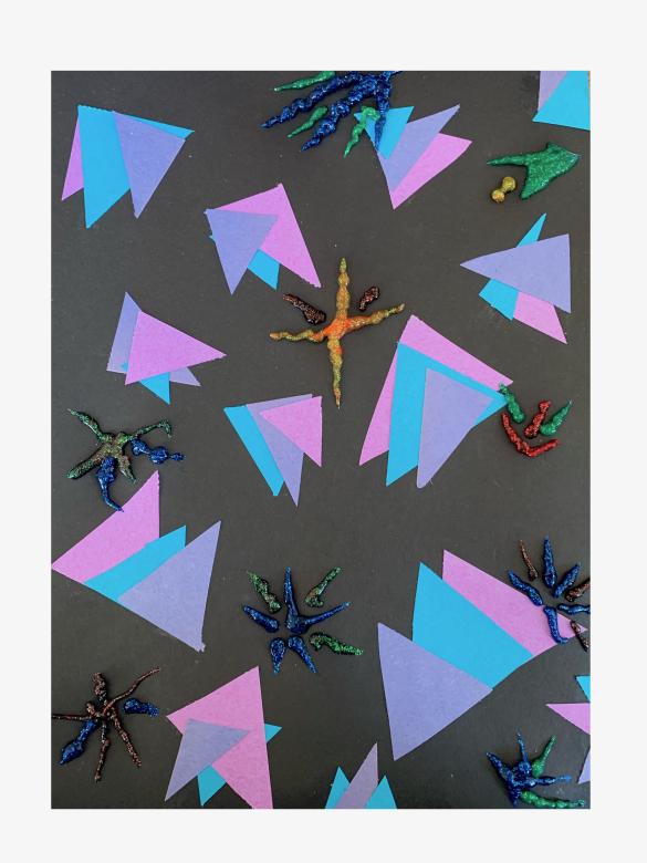 A collage of blue, purple, and magenta triangles are overlapped on black rectangular paper. "Firework" shapes of thick glitter glue are dispersed throughout. 