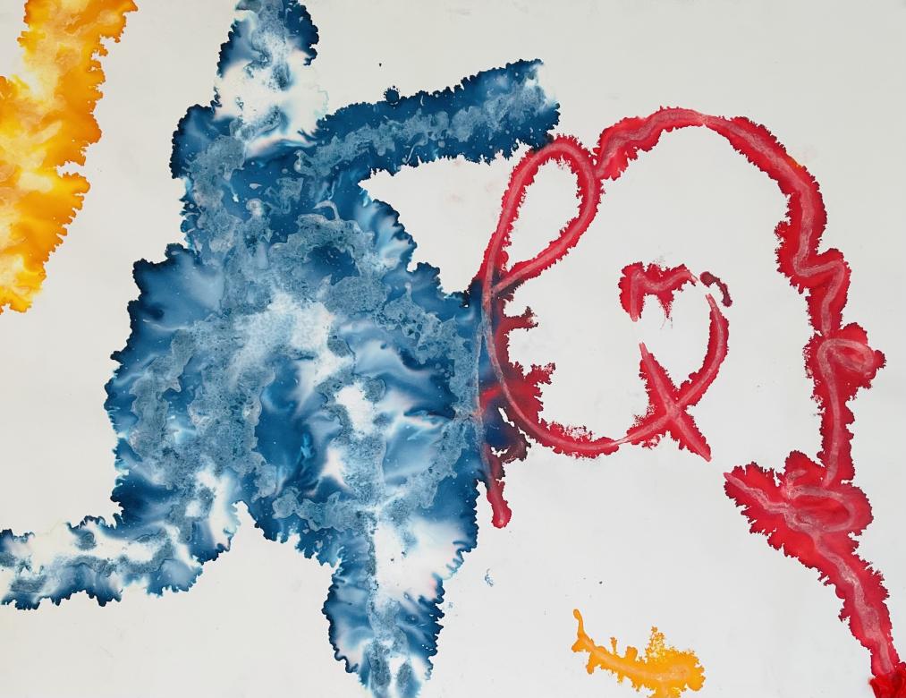 Abstract painting of large textured splashes of color moving from left to right in yellow, blue, and red on a white background. 