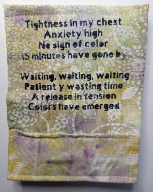 Yellow, beige, white and purple piece of cloth that reads in black text: Tightness in my chest Anxiety is high No sign of color 15 minutes have gone by. Waiting, waiting, waiting Patiently wasting time A release in tension Colors have emerged. 
