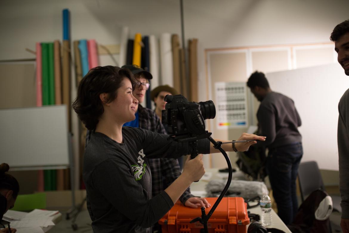 film student in class setting up camera on tripod 