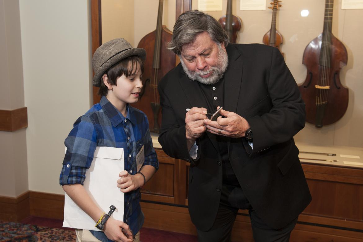 Steve Woznaik signs an autograph for a young boy