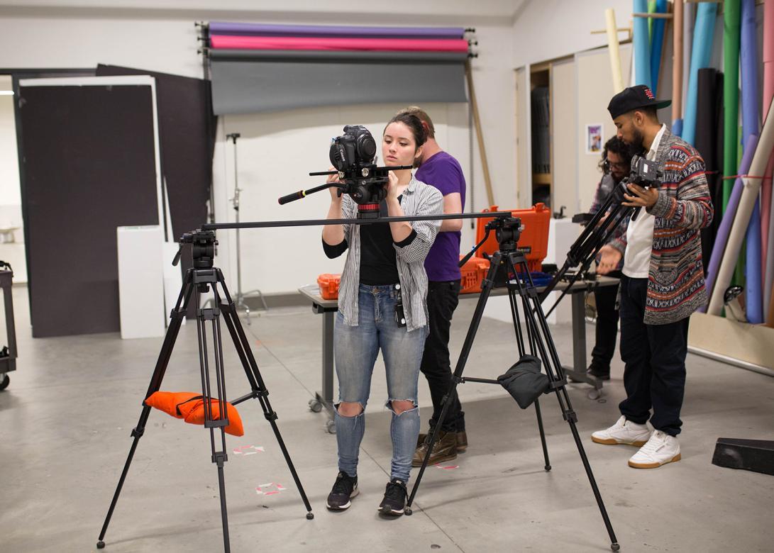 students set up film equipment in one of the classroom studios