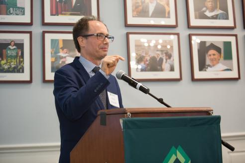 Hans Strauch speaks at a podium in Alumni Hall