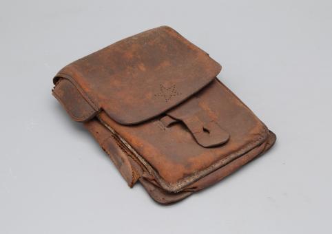 A photograph of a brown leather pouch with a star on it.