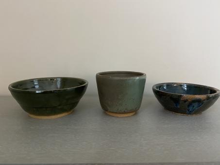 A dark green finished bowl, serpent-colored finished cup, and small blue and brown finished bowl.