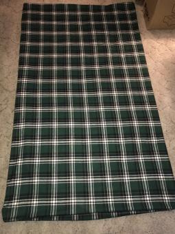 A green, white, and black plaid flannel weighted blanket laid out on the floor. Dimensions 48 inches by 60 inches.