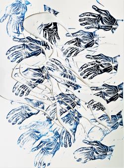 An image of repeating black and blue reductive prints of hands. The palms are facing up with lines showing the details of the hands. These hands are repeated all over the white paper with a design of swirls cut into the paper. 