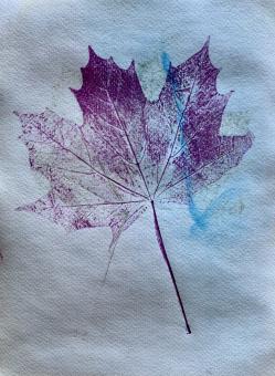 photo of purple and blue ink in the shape of a leaf on paper