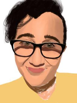 The image depicts a person from the shoulders up. They have short hair and black framed glasses. They are smiling with their mouth closed. They are wearing a yellow shirt.