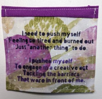 Purple, white and green piece of cloth that reads in black text: I need to push myself Feeling so tired and burned out Just another "thing" to do. I pushed myself To engage in a creative act Tackling the barriers That were in front of me.