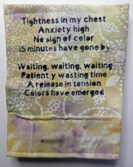Yellow, beige, white and purple piece of cloth that reads in black text: Tightness in my chest Anxiety is high No sign of color 15 minutes have gone by. Waiting, waiting, waiting Patiently wasting time A release in tension Colors have emerged. 