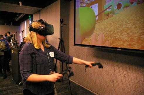 student tries out virtual reality design, wearing a headset and using hand cotrollers