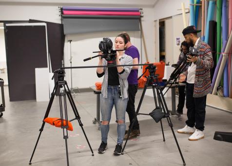 students set up film equipment in one of the classroom studios