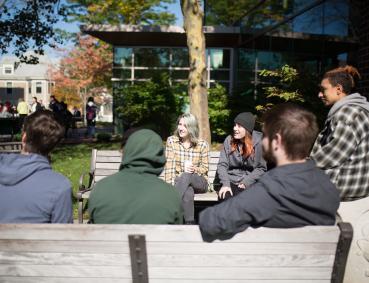 Students drinking coffee outside on the Lesley campus.