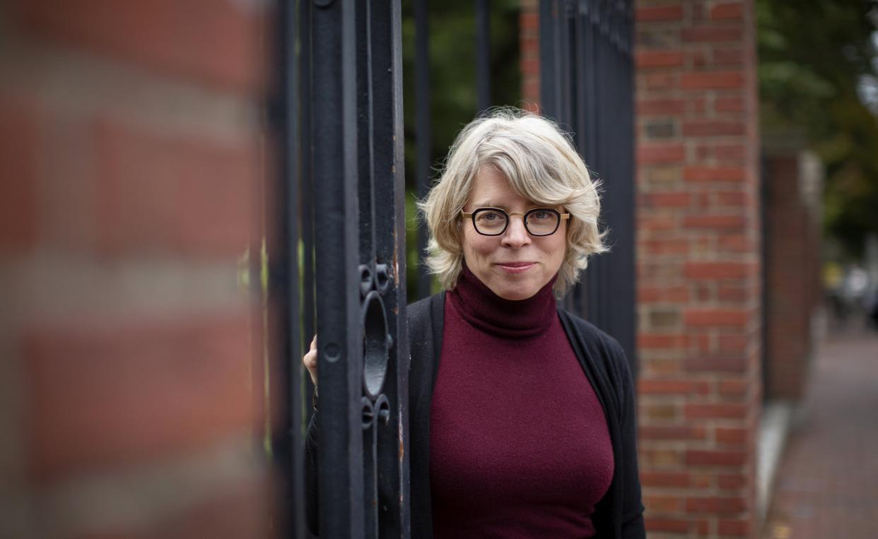 Photo of Jill Lepore standing in Harvard University gates