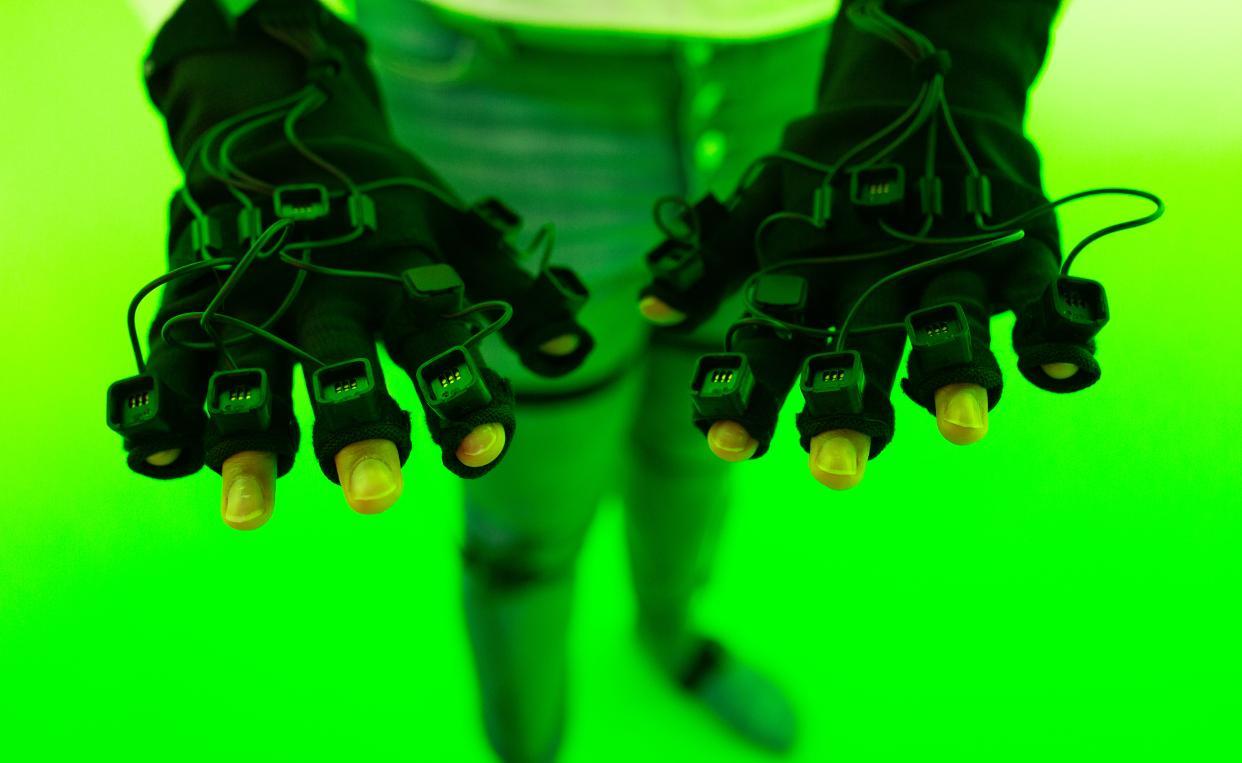 student trying out VFX equipment in green screen room