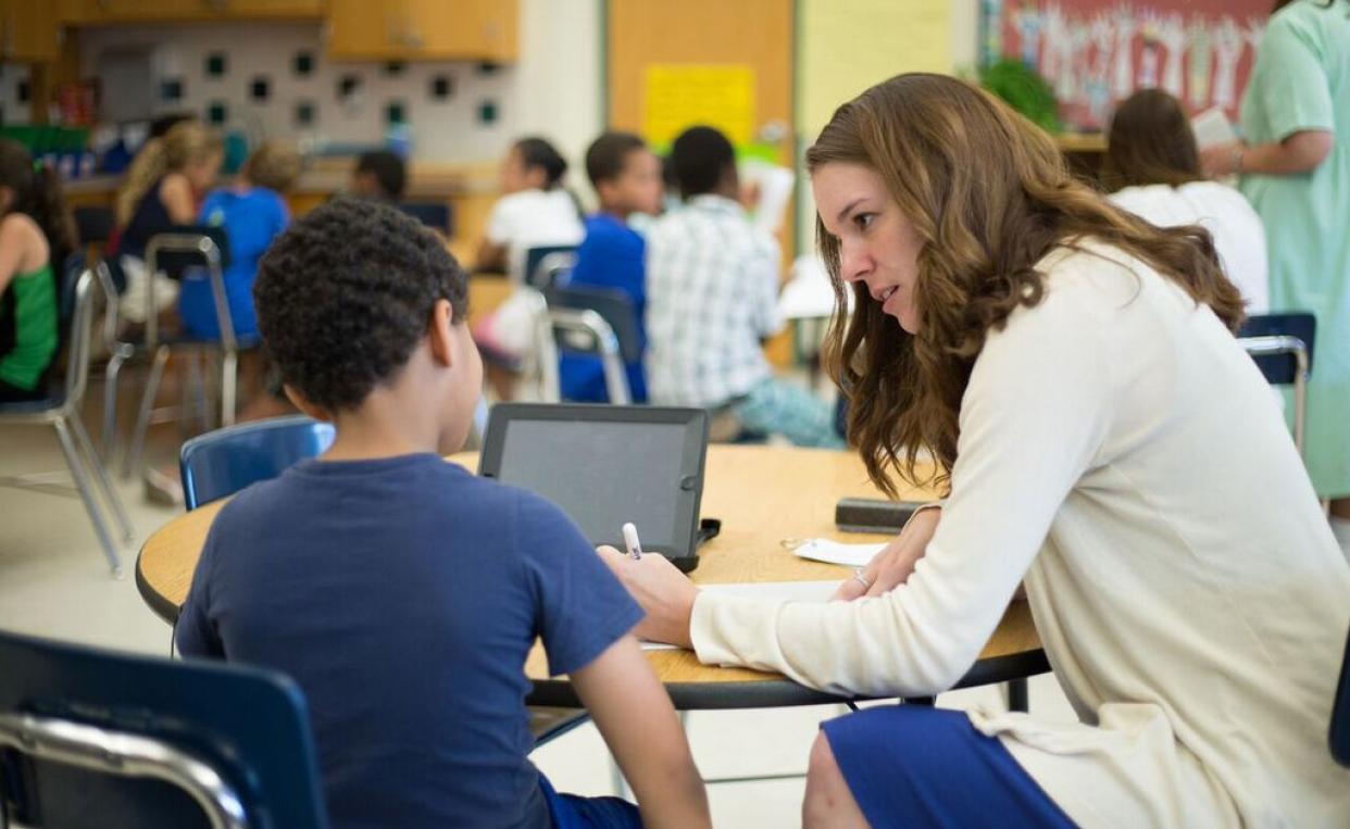 classroom teacher with boy student at table