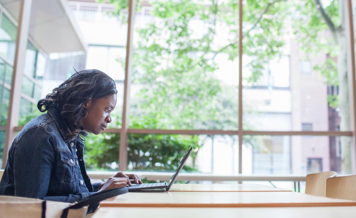 A woman typing on a laptop