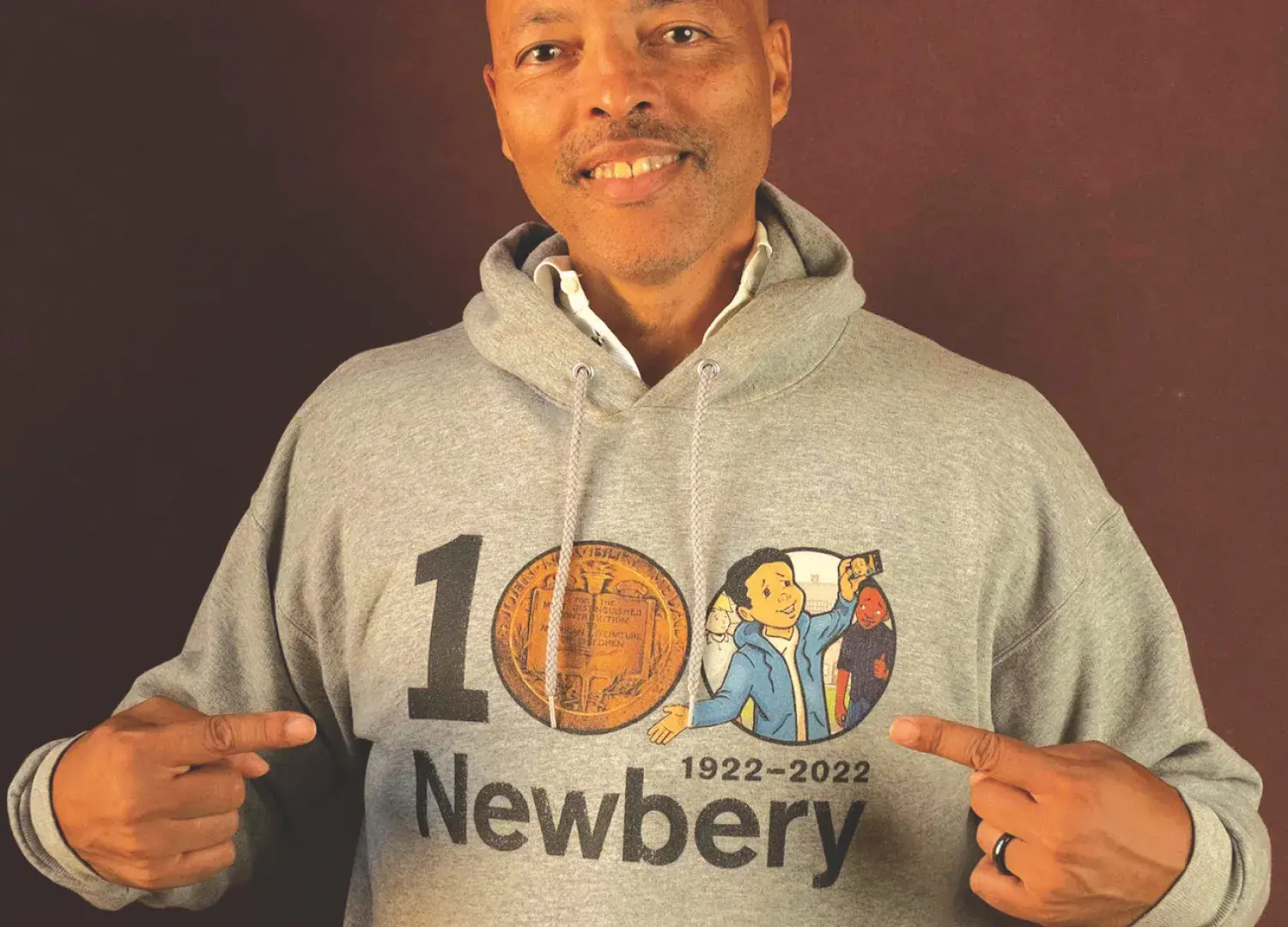 Jerry smiling wearing a sweatshirt that says "100 Newbery"