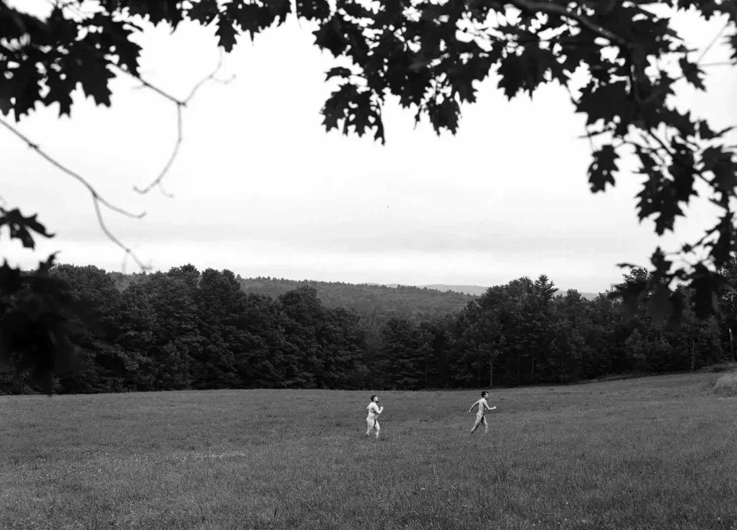Black and white photo of people frolicking in field