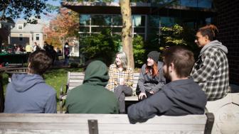 Students drinking coffee outside on the Lesley campus.