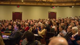 A photo of audience members seated in Symphony Hall for a Boston Speakers Series lecture.