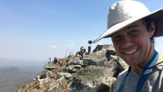 Alexander Dunn wearing a hat standing on rocky terrain