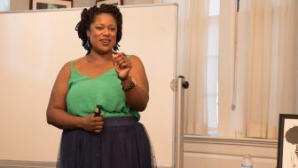Dania Peguero of Black Latina Bella Negra smiles as she speaks to the crowd.